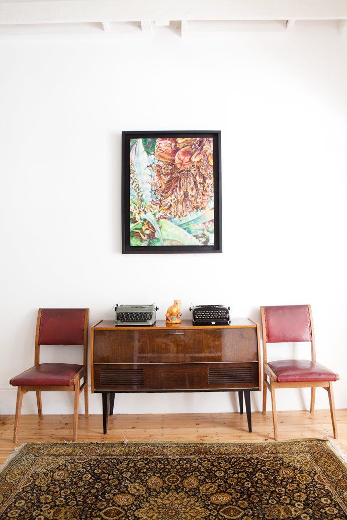 A painting by Claudia Gurwitz keeps company with a vintage radio, a Milnerton Flea Market find, and two chairs that are part of the house’s original dining set, a gift from the previous owners.
