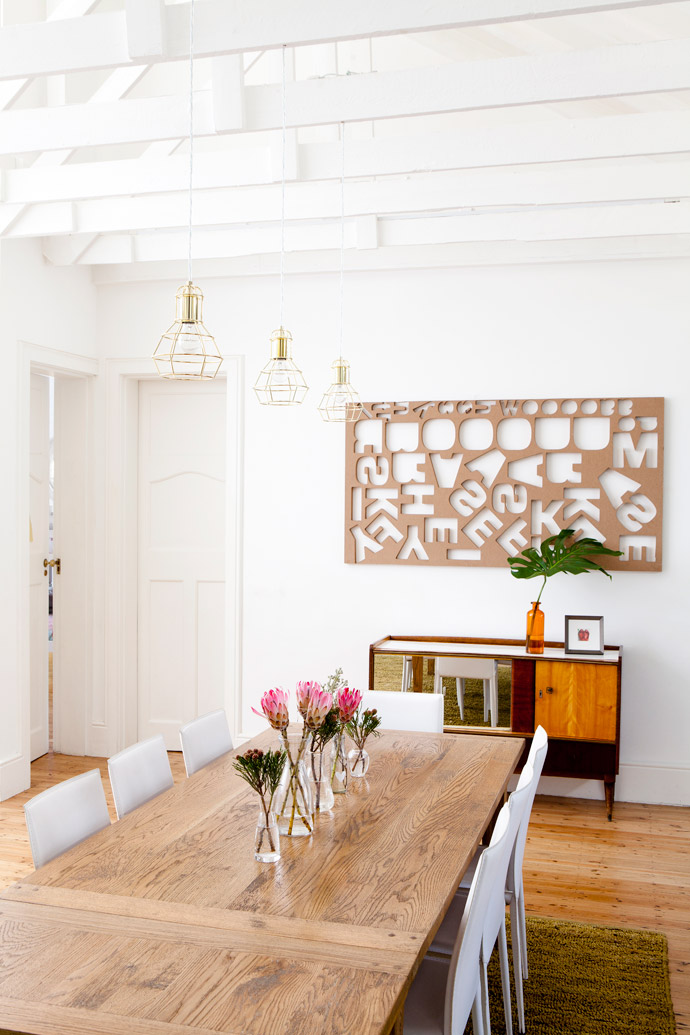 Like the rest of the house’s lighting, these authentic copper light fittings above the Coricraft dining table and chairs are the work of Cara’s father-in-law, Bernard Saven from Lightworld. The wall above a vintage cabinet is the new home of a SupaWood laser-cut panel Cara rescued from a printer’s rubbish heap. 
