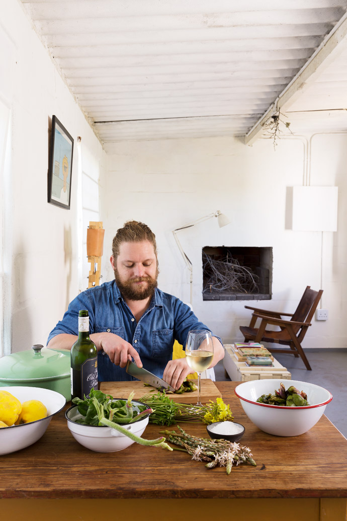 Kobus prepares a variety of veldkos at the dining table – soutslaai, veldkool and surings, all picked near his cottage