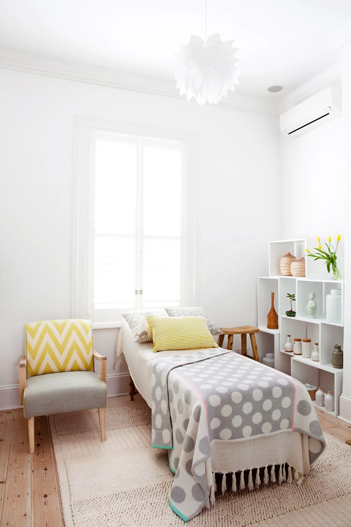 The treatment room is neutral without being clinical. The treatment bed is covered in a cream bamboo throw from Cotton Throws and a playful polka-dotted throw from Country Road, and it stands on a wool rug from Hertex.