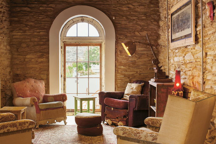 When Arthur started to remove old plaster, these lovely stone walls surfaced. The Oregon pine window frame was salvaged from a 150-year-old church. Vintage French and Italian armchairs and a restored lamp from Smileys Restoration & Creation complete the picture.
