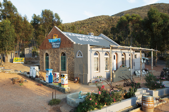 Looking splendid in the morning sun, The Karoo Moon Motel has retained a vintage vibe but is very different from the original stone-and-mud building with its cow-dung floor covering and thatched roof. Old fuel pumps, a business sign with a Koffiehuis ad and farm implements adorn the yard. The Pharos picked up these relics in towns like Prince Albert, Barrydale and Ashton on trips through the Karoo on their Harley-Davidsons.
