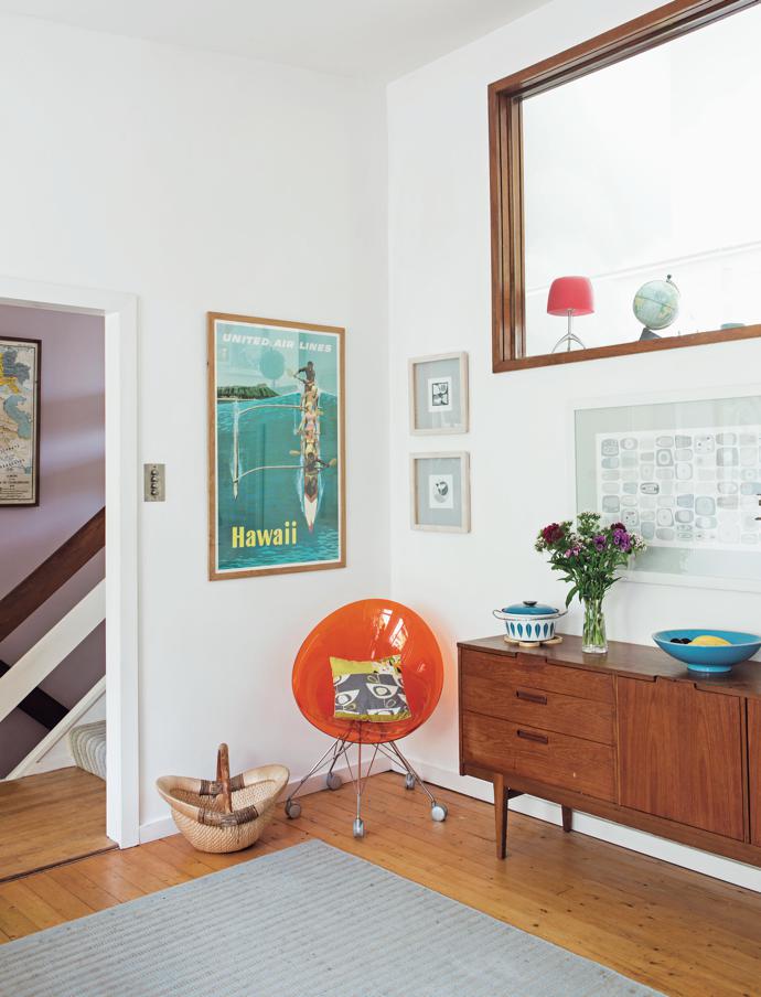 The window looks into the living room and pours light into the kitchen. One of Sarah’s
large pencil drawings hangs above the Mid-Century sideboard and is complemented by the bright orange chair and the strong blues in the pot and bowl and the poster. ‘The bright and happy Hawaii poster is
my favourite thing in the kitchen,’ explains Sarah.