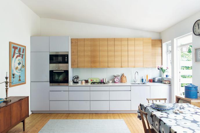 The simple but beautifully designed
kitchen ‘was built by my friend Steve, which makes it extra special to me,’ says Sarah. The grey cupboards are reminiscent of one of Sarah’s designs, with the pops of colour found in the kitchenware and posters working like the carefully selected colours Sarah uses in her work.