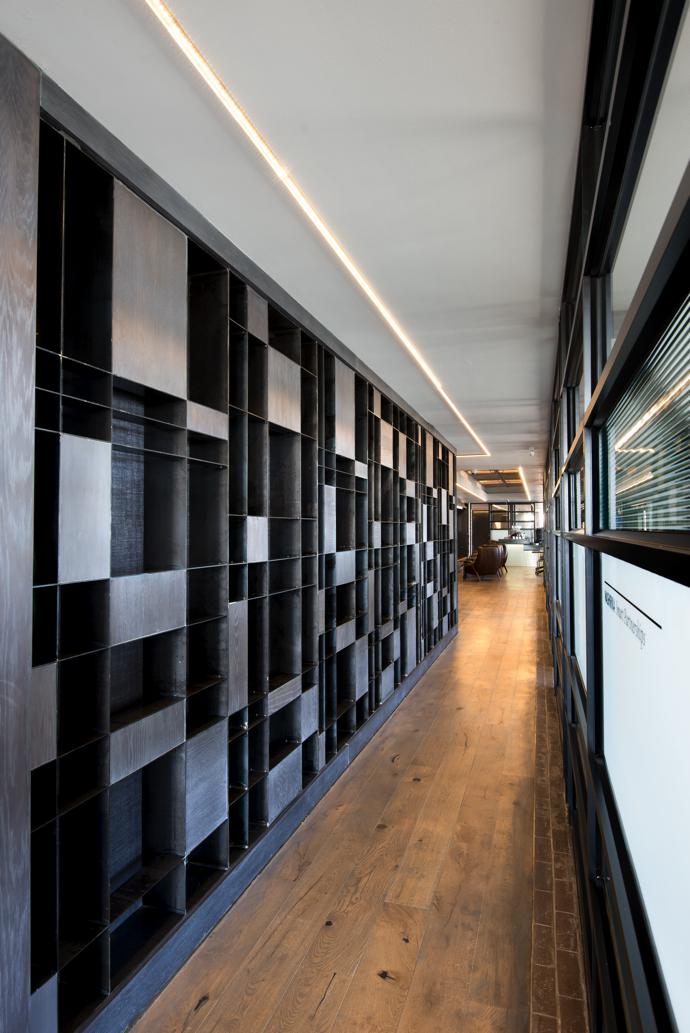 A Mondrian-inspired steel-and-oak wall unit awaiting books references the theme of intersection and strong use of lines.