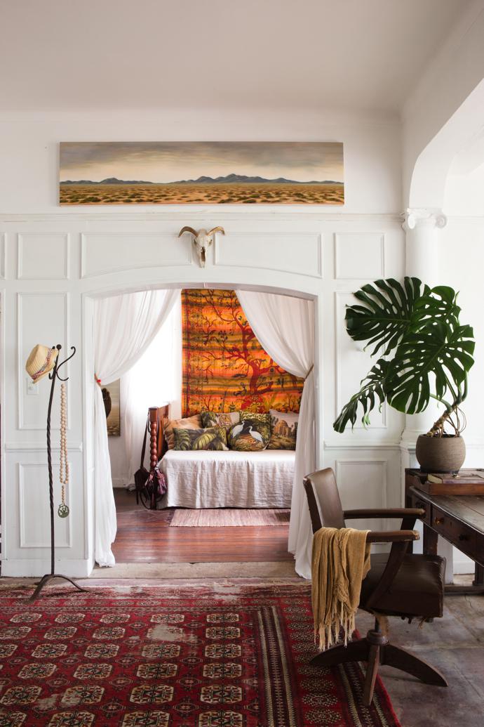 The former hotel bar area was converted into a comfortable space for guests. The day bed, the study chair and the worn old Persian carpet are from various antiques shops. Harem bought the orange wall hanging in Arambol on a trip to India, and the linen cushions on the day bed are from HOT COFFEE. The metal hat stand was all that survived when Harem’s farmhouse in the Lowveld burnt down.