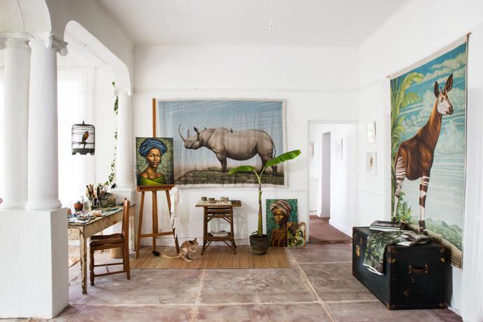 Harem chose this corner for his painting studio because of the good natural light. The old work bench was a gift from a friend, the spring hare is from Mandibles in Woodstock, the antique bird cage is from Cape to Cairo in Kalk Bay and the traveller’s trunk is from Kalk Bay Trading Post. The linen wall hangings of a rhino and okapi are two of Harem’s works printed on linen by HOT COFFEE.