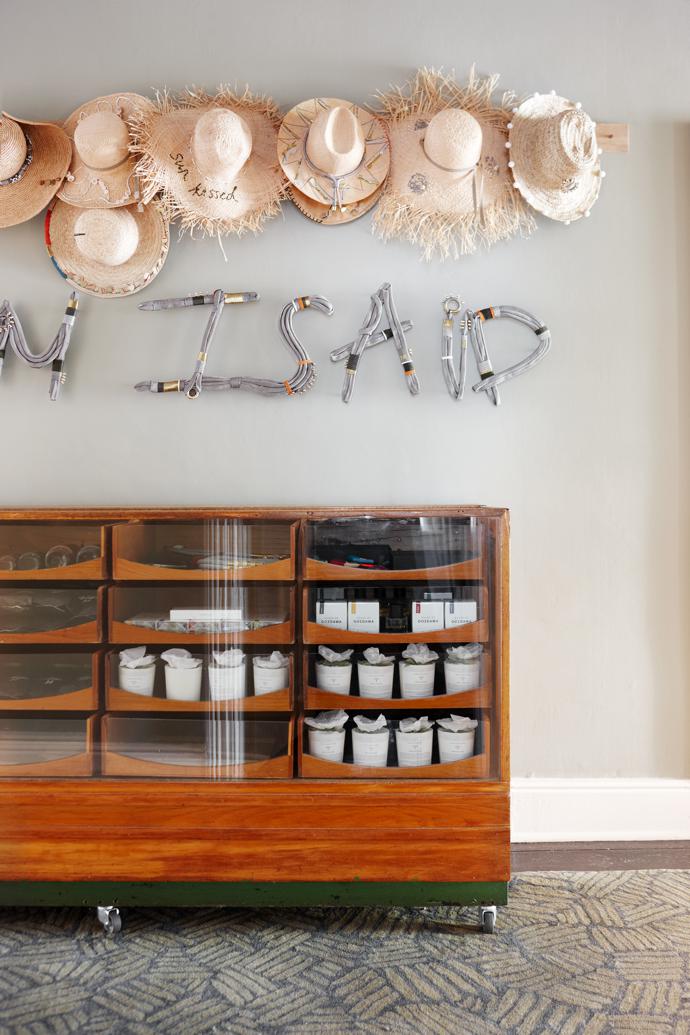 In the hallway, the hats on the wall and the art installation are by Pichulik. The rug beneath the antique haberdashery unit is from Gonsenhausers.