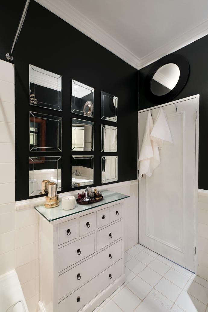 The tiny bathroom works hard to create space with mirrors on the walls, a repainted chest with extra drawers and a nifty overhead rail where washing can be hung above the bath on wet days.