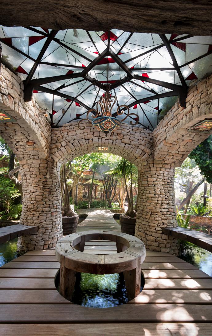 The antechamber to the main living area is a serene space with a glass and-metal ceiling and chandelier by Luke Atkinson.