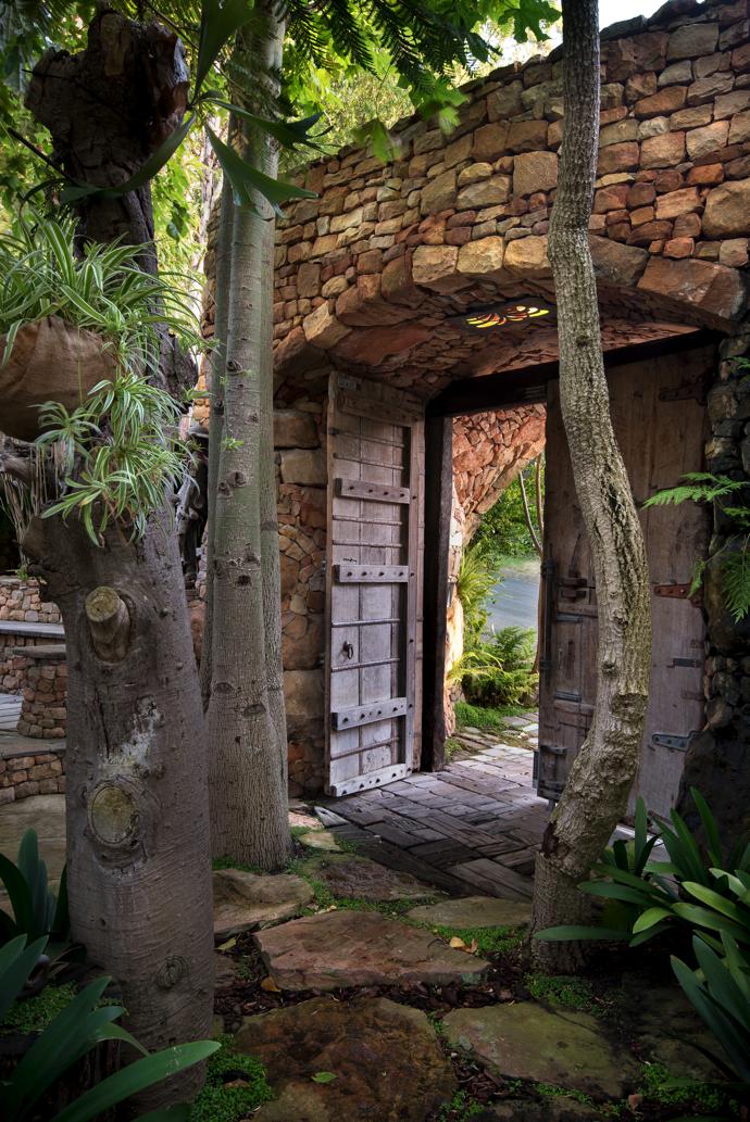 Entering through these majestic wooden doors from the street, you find yourself in an organic paradise that reveals its secrets step by manmade step.