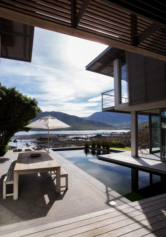 Water is circulated between two pools, and the roots of aquatic plants in the one pool filter the water and keep algae under control. No chemicals are needed. The house has a number of passive-envelope features, such as slatted overhanging eaves, screens and a canopy that prevent glare; provide dappled shade; and fragments the form of the house, allowing it to recede into its natural setting.