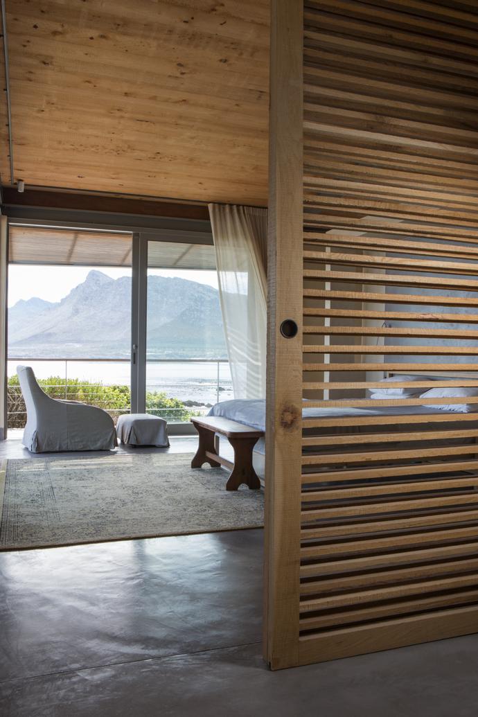 In the spacious main bedroom, slatted oak sliding screens by Jonathan Cooper can be drawn closed for privacy. The furniture is from Weylandts.
