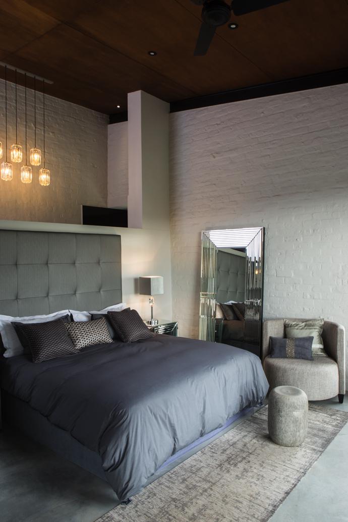The guest bedroom features a headboard manufactured in high-quality vinyl, which is also found in the main bedroom. The walls are all white, with colour introduced in the form of glitzy furnishings, lighting and other decor items. The freestanding multi-bevelled Athena mirror was made by hand.