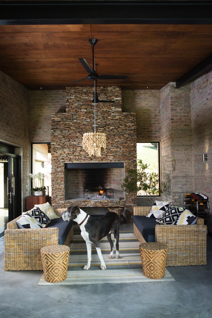 Malibu cane outdoor couches complement the brick and stone-clad braai area, where Judith and Francis love to light a fire. A large rectangular wooden chandelier is suspended from the ceiling. The furnishings and lighting are all from Isabelina.