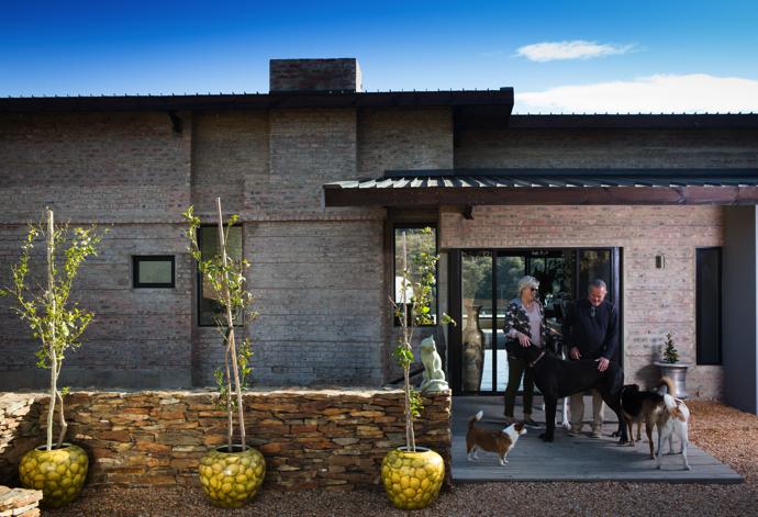 Judith and Francis in front of their house with their five beloved dogs.