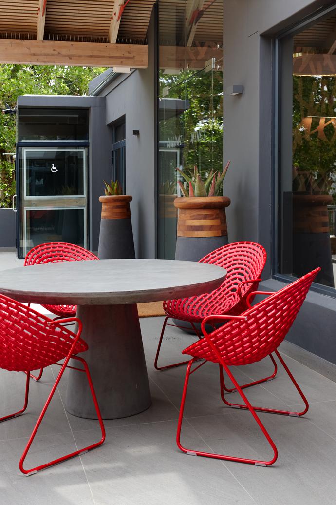 Zulu Mama café chairs, another classic Haldane Martin design, and Soma planters by Laurie Wiid van Heerden for Indigenus at the entrance to the building.