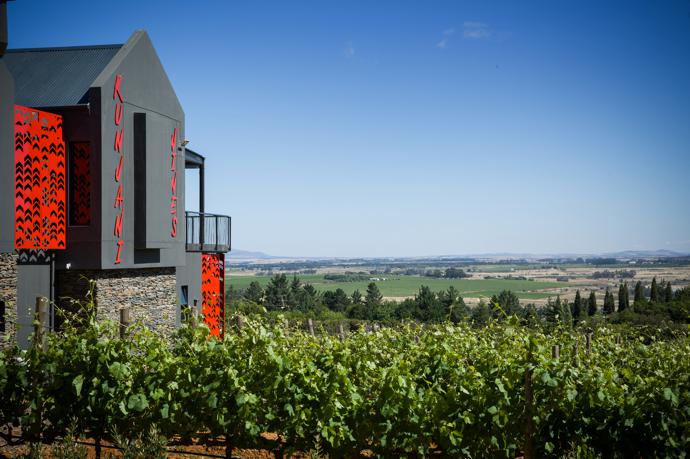 Not your traditional Cape Dutch style building! The bright red of the screens, with their chevron like shapes that evoke traditional West African hut decorations, and the bold signage contrast deliberately with the green of the landscape.