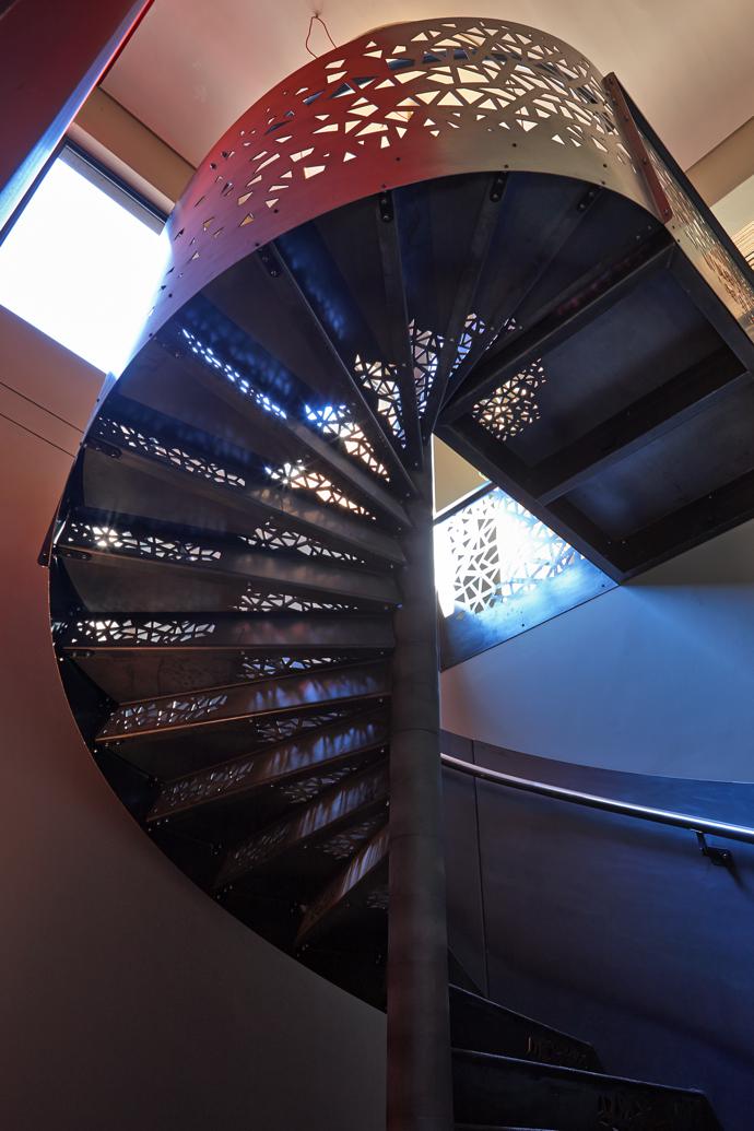 The spiral staircase leading down to the cellar has Voronoi pattern cutouts to evoke a descent into the Earth.