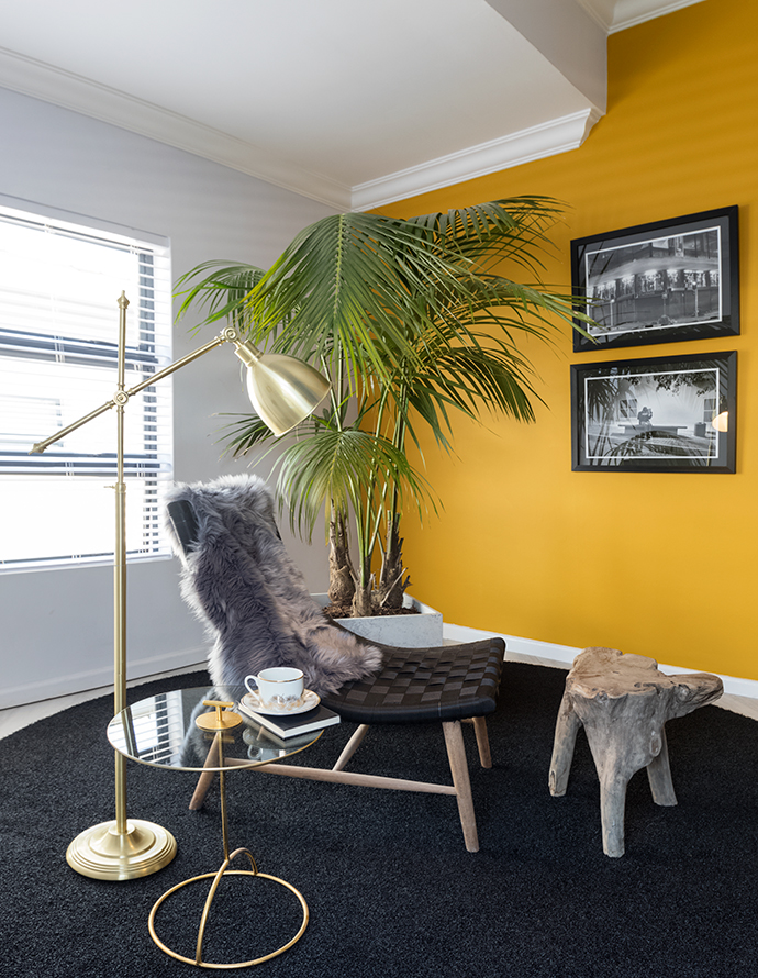 In the music room, a palm tree in a Caeserstone planter and photographs by Mpho Mokgadi fit the unit’s concrete jungle theme. The chair and footstool are from LaGrange Interiors, the side table is from Zara Home and the lamp is from @home.