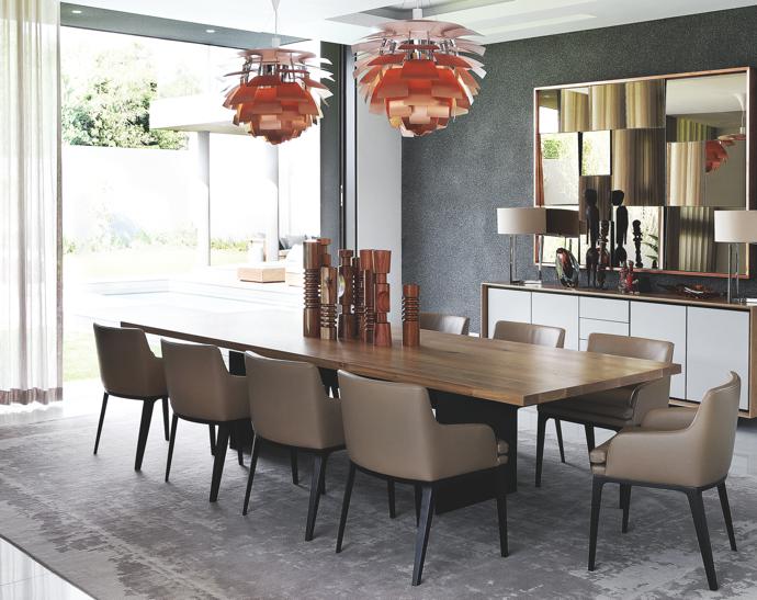 The mahogany Mojo candlesticks on the dining table and carved tribal-figures in front of the faceted mirror form part of the owner’s African art collection.