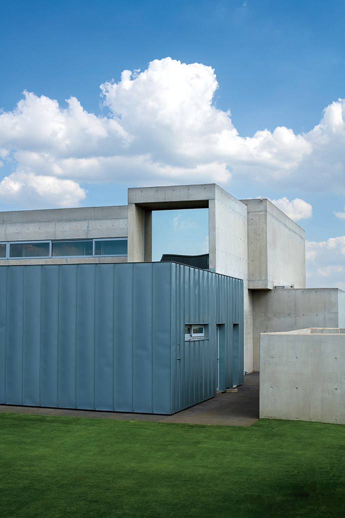 Dominique clad the utility box in Rheinzink. Alongside it, behind concrete walls, the VRV air-conditioning system, back-up generator and heat pumps all aid the house in running with a low energy output. The main bathroom with its large one-way-glass window protrudes from the plane of the top floor.