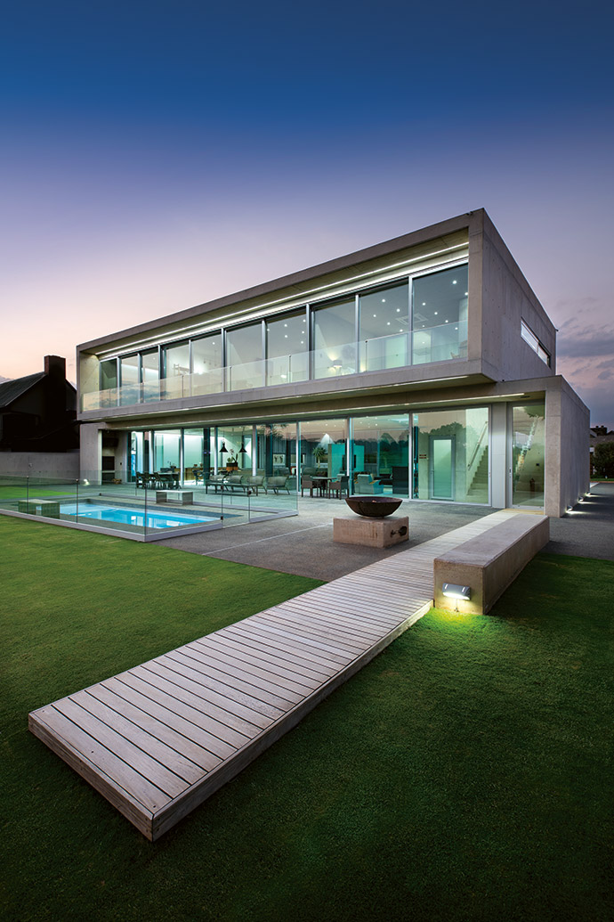 The south face of the house clearly demonstrates the two stacked cubes, with a 3 m-deep cantilever creating a sizeable patio that the Smiths use all summer long. The three bedrooms and the living areas all look out onto the garden and golf course.