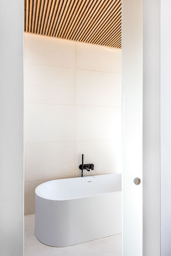 A luxurious oval soaking tub maintains the minimalist theme.