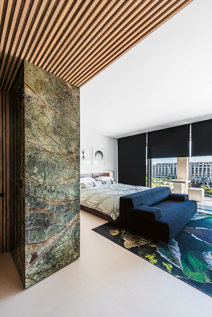 Although colour is not a prominent feature in the apartment, this guest bedroom introduces a slight contrast with a leaf-printed carpet.