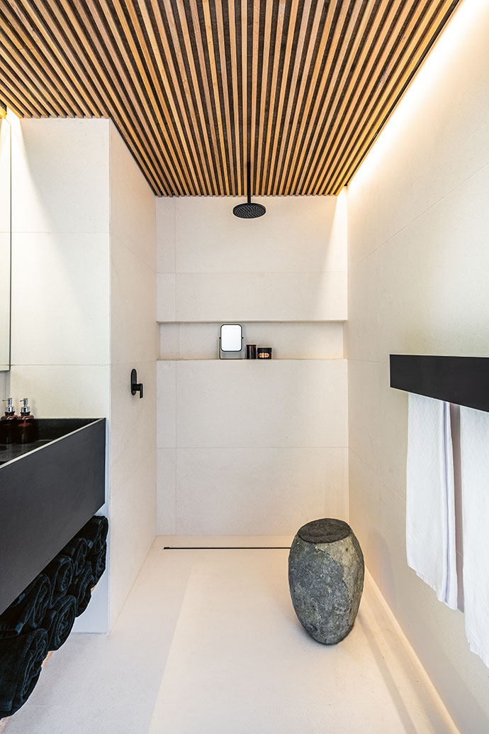The guest bathroom combines all the elements present in the rest of the home, from wood to marble.