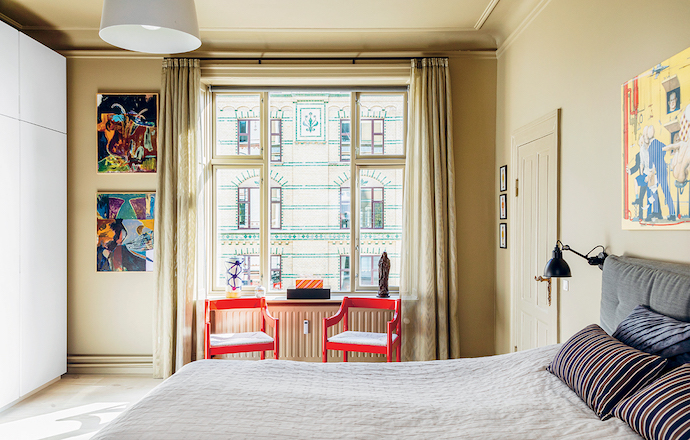 The window in the master bedroom frames a view of a perfectly preserved heritage building in Østerbro.