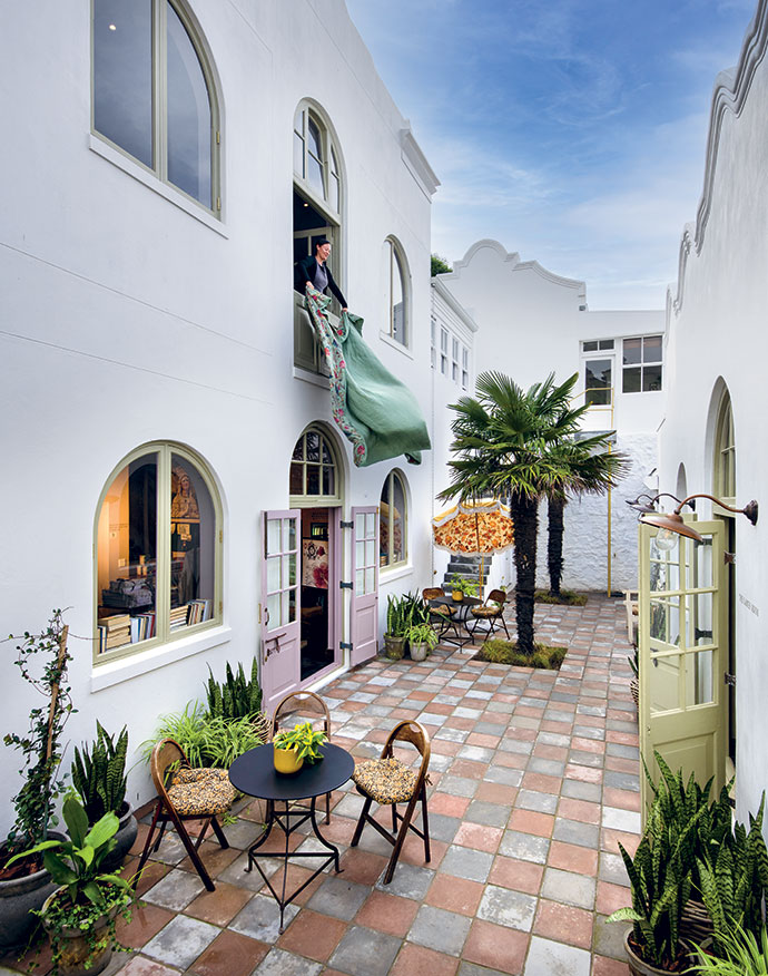 Meagen Jongebloed, Gail Behr’s accomplished pattern maker, unfurls one of Dorp’s handmade coverlets, for sale in the shop below.