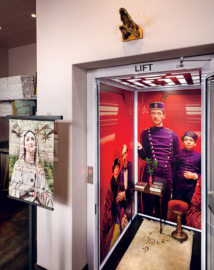 The shop lift, wallpapered with scenes from Wes Anderson’s The Grand Budapest Hotel, replete with red velvet stool, carpet and table – a mini set referencing one of Gail’s favourite films.