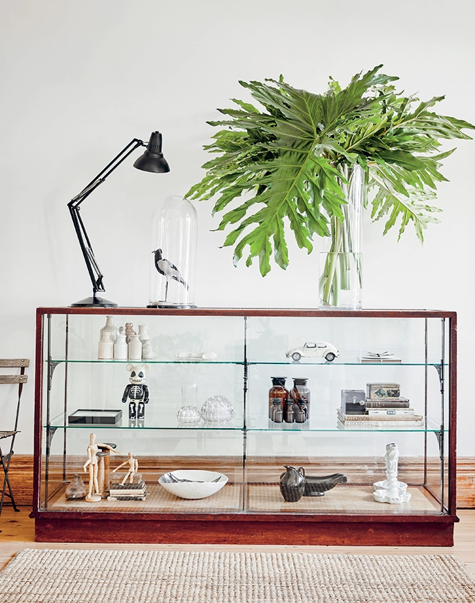 To maintain an open feel in the hallway, Sanet positioned a vintage display cabinet from Wauhaus against a wall. It’s home to a butterfly by botanical artist Chris van Niekerk; white ceramics by Ceramic Matters; a Hylton Nel bowl; and vintage earthenware, crystals and glass. The Anglepoise lamp is from Haute Antiques.