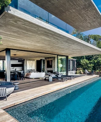 The open-plan living area overlooks an infinity pool that seemingly spills over into the sea and city view.