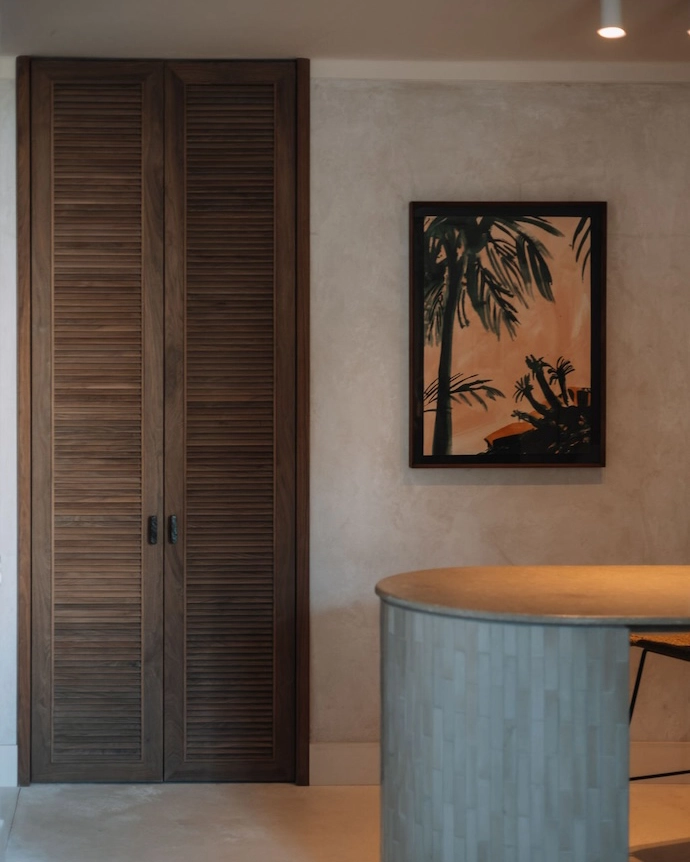 Vrede Apartment by Matter Studio – a wooden door, kitchen island and south african artwork on the walls of Vrede