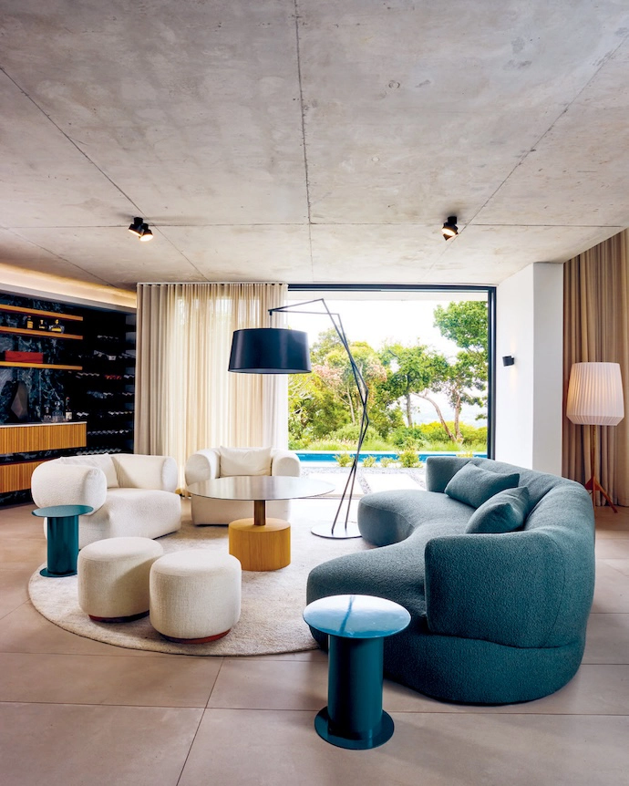 Interior designer Hendre Bloem demarcated the vast open-plan architecture with pockets of intimacy, such as this vignette starring a bespoke curved couch and swivel armchairs, illuminated by a standing lamp from Dark.