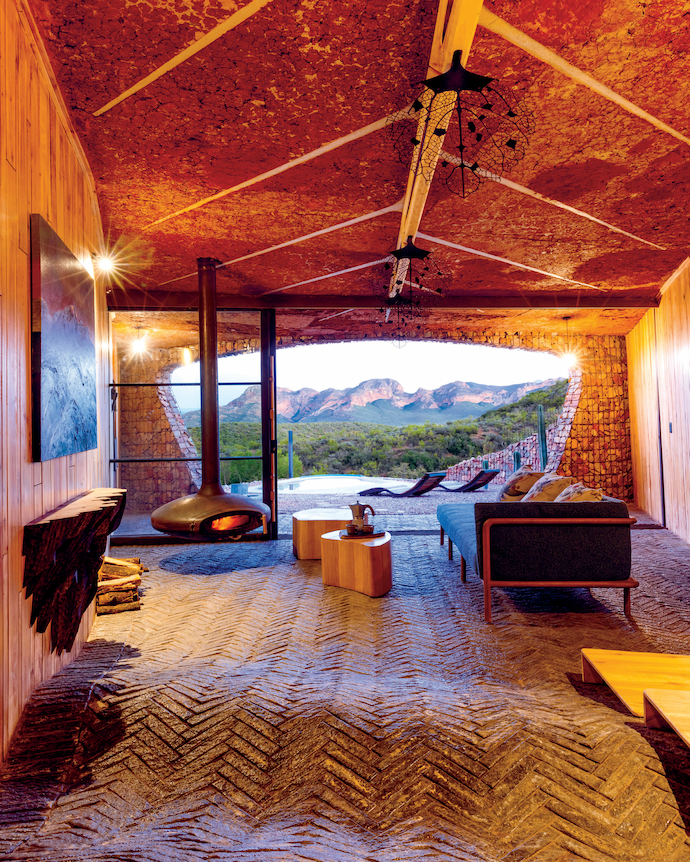 A painting of the Swartberg mountains by Hermann Niebuhr hangs above the Cliﬀ server by Meyer Von Wielligh, made of alien red river gum and inspired by the magnificent cliﬀ edges of Meiringspoort. The leaf pattern on the ceiling is concrete cast on a thin layer of mud that comes from the dam 200m away. The Melike sofa is also by Meyer Von Wielligh.