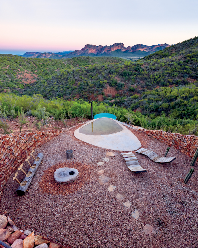 The rim-flow hot tub is made of the same reclaimed metal silo as the front door, and is heated by lighting a fire under it.