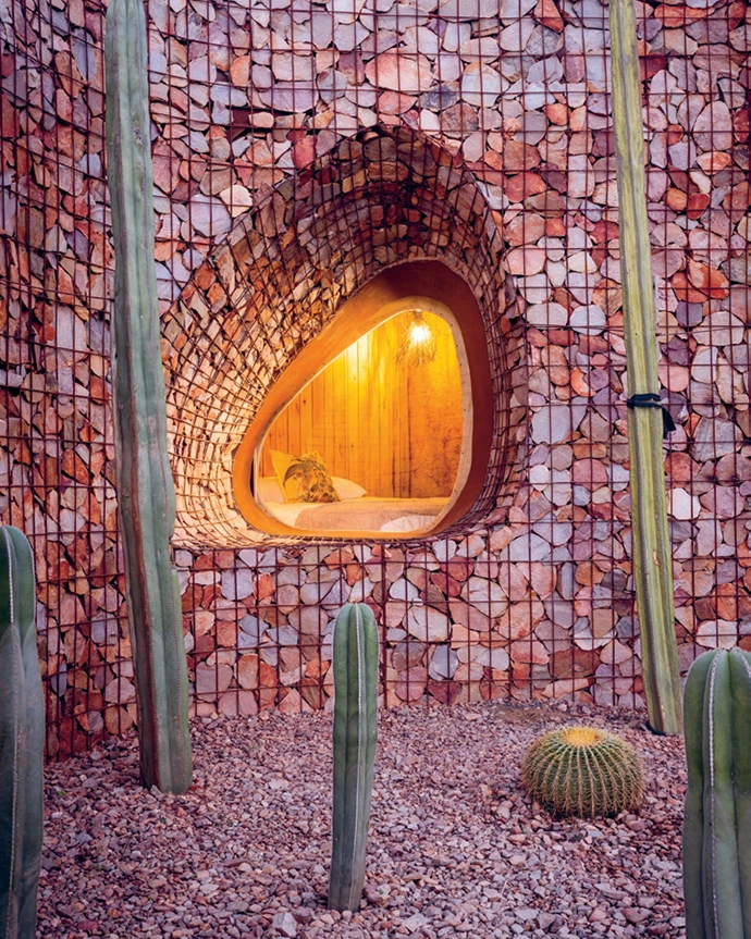 An organic-shaped window tapers outwards like an old telescope, providing a view of the mountains from the second bedroom.