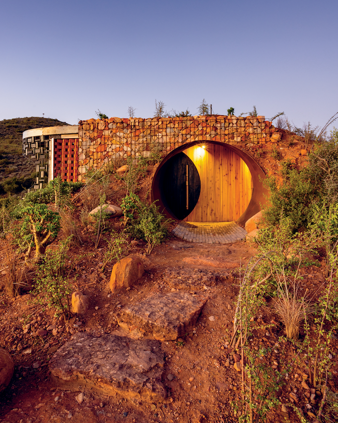 The heavy front door is made of an old reclaimed metal silo clad in treated poplar – a type of wood common in the Karoo. 
