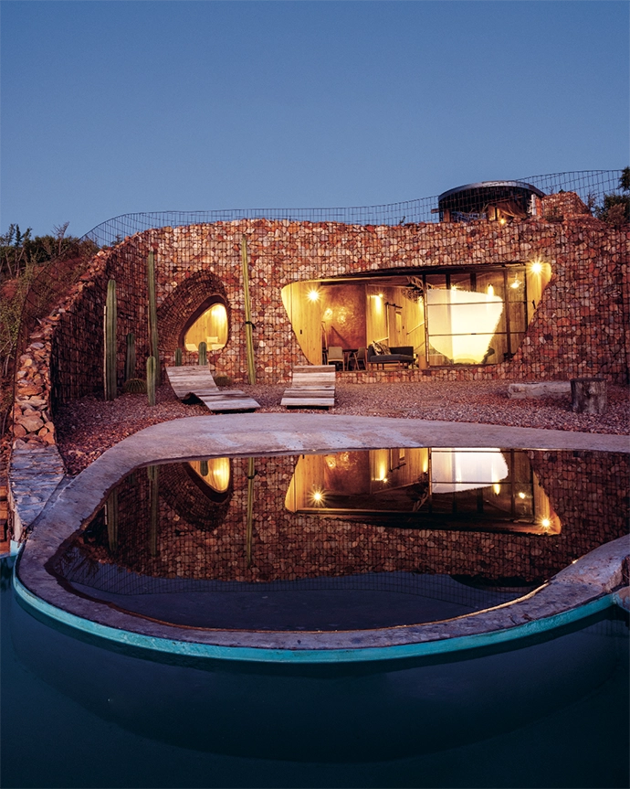 The gabion-style retaining wall is packed with stone from the surrounding koppies. Each pebble- shaped rock was cracked by hand to get a fl at surface, then packed into the steel mesh. The plunge pool gradually deepens towards the front edge. 