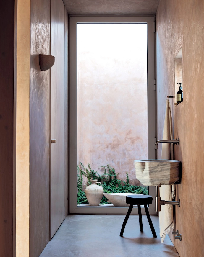 At the end of the passage to the three bedrooms, an antique marble baptismal font has been installed as a basin.