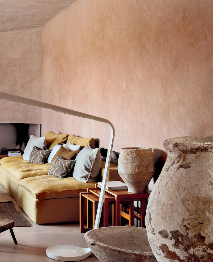 Bathed in light, the lounge features two 1970s armchairs by Tobia and Afra Scarpa, found at an antique dealer in Madrid, and an ochre sofa by Restoration Hardware. The carpet was woven from vintage wool blankets by artisans in the Alentejo region, and the coff ee table, wooden milking stools, XXL fl oor lamp and Scandinavian nesting tables were all found at the Rastro flea market in Madrid.