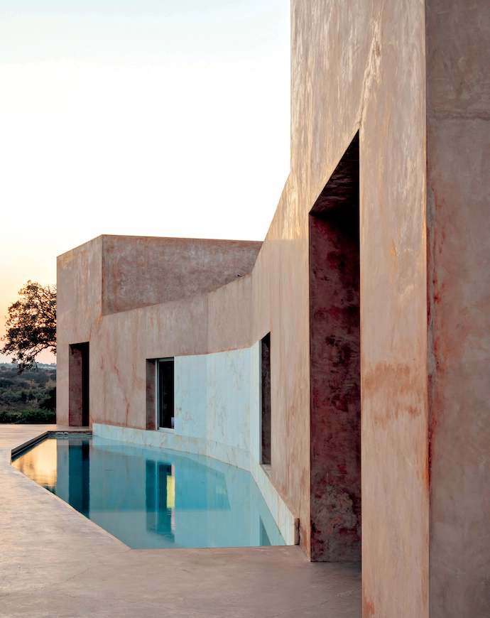 The pool, lined with Aquabright coating in light blue, shares a wall with the house – this has been laid with marble slabs that complement the plasterwork. 