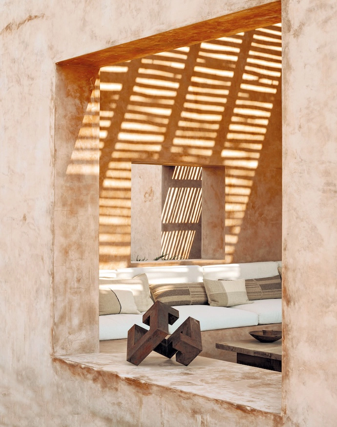 On either side of the vast living room, two outdoor terraces are shaded by an awning of eucalyptus branches to filter the sunlight.