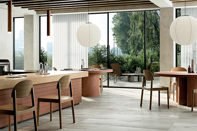 A fresh and vibrant Crystal Wintergreen concrete kitchen floor by Ceramica, together with palette cohesion and matching seating, enhances the connection between the cooking, dining and outdoor areas