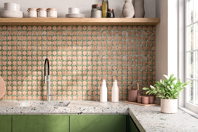 Subtly patterned Tetuan Cotto Emerald tiles by Decobella add just the right amount of visual interest without overwhelming the space, and perfectly complement the green cabinetry and natural stone countertops. 