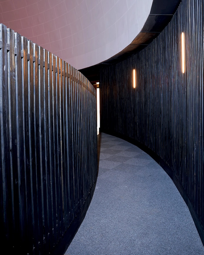 The way into the auditorium features dark wood acoustic panelling. Architect Kate Otten points out that it was stained dark so that it wouldn’t reflect light during projections.