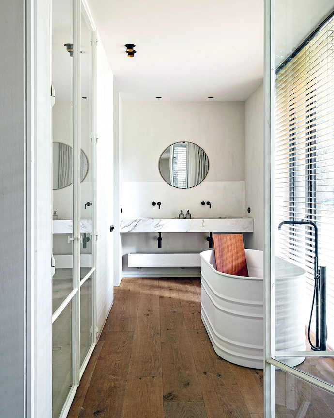 The main en suite bathroom features a Vieques XS bathtub by Patricia Urquiola for Agape, a Sahara Blanc marble vanity by Moka Tales and VOLA tapware by Arne Jacobsen.